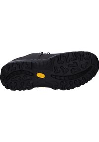 Schwarze Gummisohle mit tiefen Profilmustern, die in der Mitte ein gelbes Vibram-Logo zeigt. Robustes und strapazierfähiges Design für einen besseren Halt.