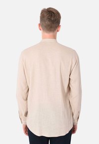 Camicia a maniche lunghe in lino beige chiaro con colletto alla cinese, presenta una vestibilità ampia e polsini con bottoni. Tessuto morbido, design casual.