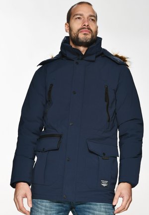 Marineblå polstret parka-jakke med pelsforet hætte, lynlåse og knaplommer samt justerbare ærmer. Kraftig isolering for varme.