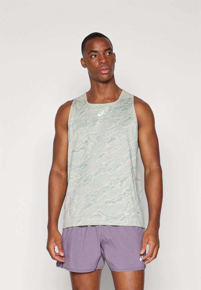Débardeur de sport vert clair avec un motif de vagues texturé et un logo, associé à un short violet. Tissu durable avec une coupe décontractée.
