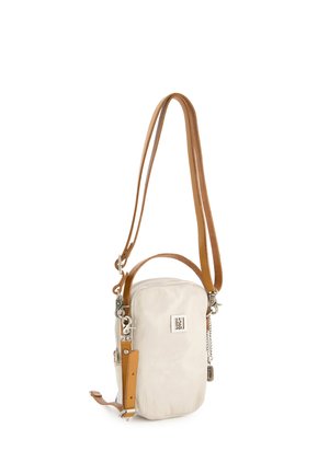 Mała pionowa beżowa skórzana torba na ramię z regulowanym jasnobrązowym paskiem, srebrną tabliczką z logo i akcentami z łańcuszka na białym tle.