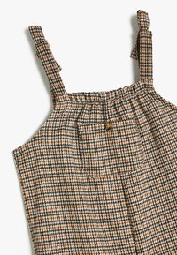 Brun och svart rutmönstrad klänning med justerbara axelremmar, smockad byst och knappdetalj, tillverkad av texturerad tyg.