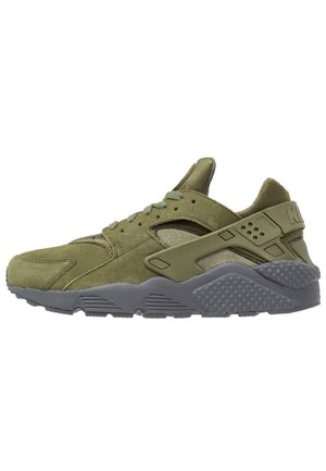 Baskets vert olive avec semelle grise, dessus en daim et mesh, maintien du talon en plastique, fermeture à lacets vues de côté.