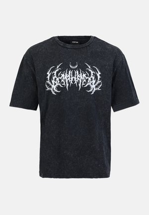 T-shirt noir à manches courtes avec une texture usée et un imprimé graphique blanc présentant des motifs dentelés et un croissant de lune.