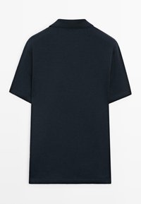 Polo à manches courtes bleu marine uni vu de dos, avec un col simple et sans logo ni motif visible.