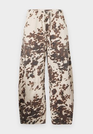 Cotton blend wide-leg pants in beige with a brown splatter pattern. Features an elastic waistband and two side pockets.