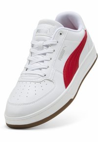 Hvid sporty sneaker med en rød side-stribe, struktureret læderoverdel, perforeret tå og gummisål. Har hvide snørebånd og branding.