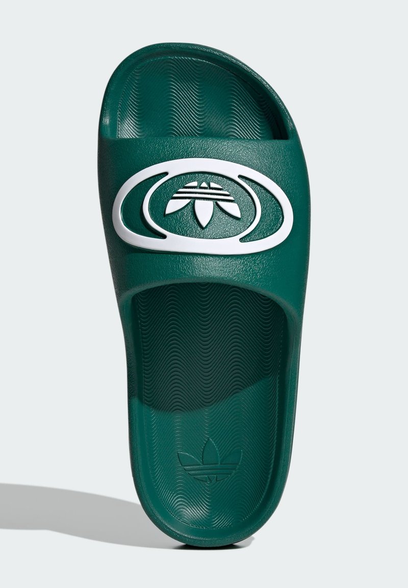 Grøn slidesandal med en tekstureret overflade og et hvidt logo. Designet inkluderer en formet fodseng og åben tå.