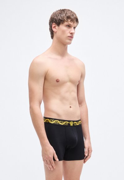 Μαύρα ανδρικά εσώρουχα boxer με υφασμένη κίτρινη μέση που διαθέτει διακοσμητικό μοτίβο. Μαλακό ύφασμα με εφαρμοστή σχεδίαση, κατάλληλο για καθημερινή χρήση.