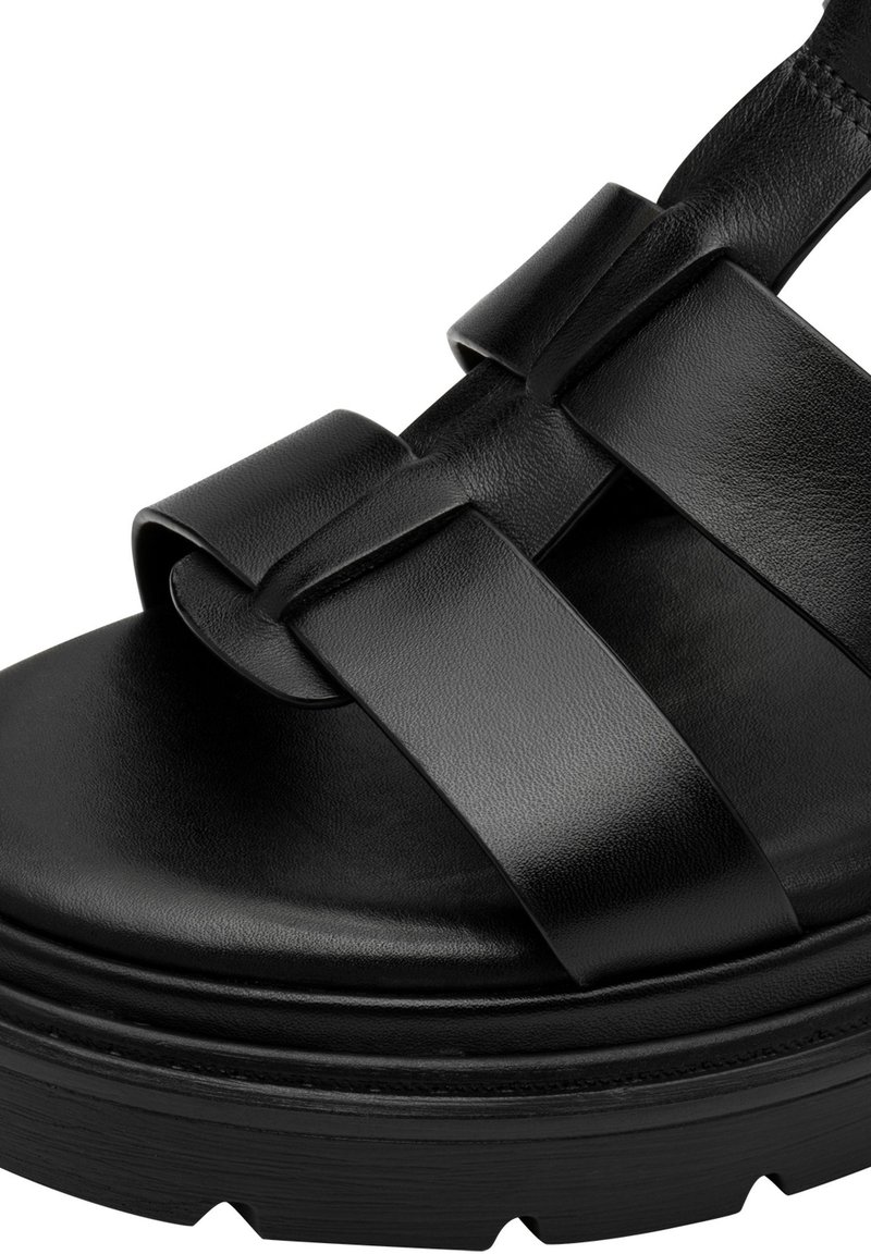 Schwarze Plateau-Sandalen aus Leder, ausgestattet mit breiten Kreuzriemen, einer glatten Oberfläche, einer dicken Sohle und einem profilierten Profil für besseren Halt.