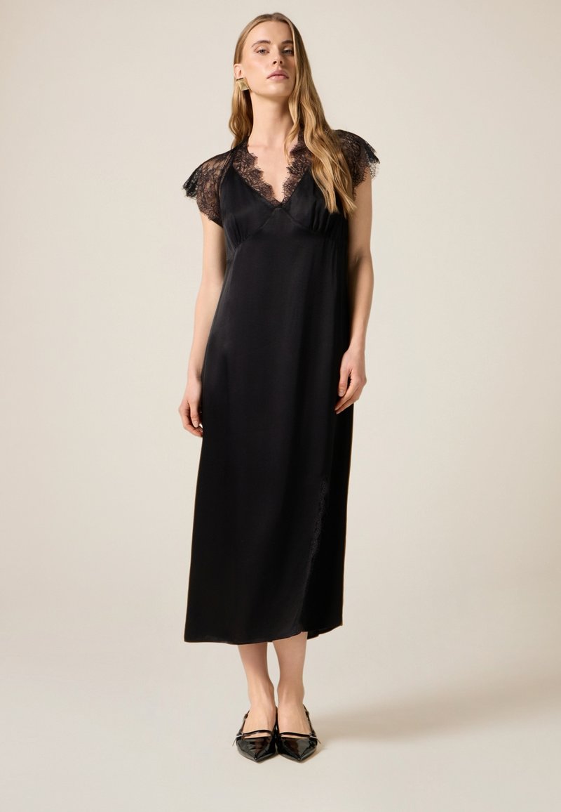 Zwarte satijnen jurk met een diepe V-hals, kanten mouwtjes en een zijschuifdetail. De stof heeft een gladde textuur en een strak ontwerp.