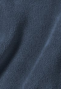 Tessuto in pile blu scuro con una superficie morbida e testurizzata. Il materiale appare soffice e leggermente riflettente, mostrando un colore uniforme e liscio.