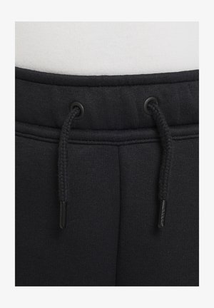 Black sweatpants with a drawstring waist, featuring a smooth texture and reinforced stitching. Includes black eyelets for drawstring attachment.