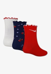 Τρία ζευγάρια κάλτσες πλήρους μήκους: λευκές με βολάν στο πάνω μέρος· μπλε σκούρες με μοτίβο κερασιών· κόκκινες με λευκό λογότυπο Nike, όλα με ριμπ υφή.