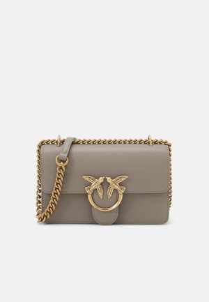 Grå læderhåndtaske med en kædeæske i guldfarve, der har et dekorativt fuglemotiv og en cirkulær hardwaredetalje. Glat tekstur, rektangulær form.