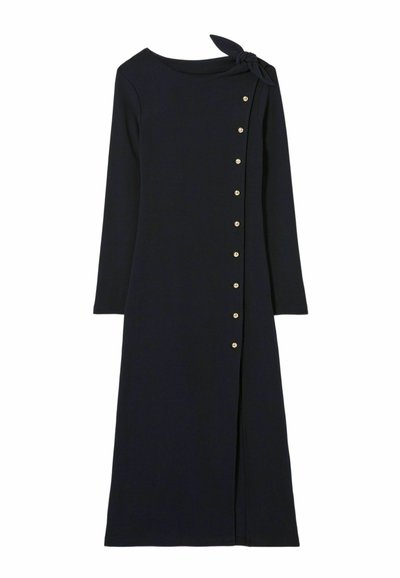 Robe bleu marine à manches longues avec un col rond, accent de nœud sur le côté et boutons dorés sur le devant. Texture lisse et silhouette cintrée.