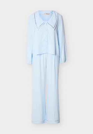 Modro obarvana pižama z dolgimi rokavi, z gumbi in širokim ovratnikom ter ujemajoče ohlapne hlače, obe z okrasom v obliki valovite obrobe.