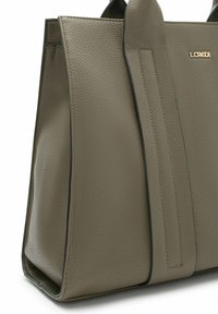 Sac fourre-tout en cuir texturé vert olive avec deux poignées, arborant un logo doré et des bords plus foncés contrastants le long des coutures.