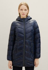 Marinblå pufferjacka med en chevron-quiltad design, hel dragkedja, huva och sidofickor; slät, sk shiny tyg med en lätt känsla.