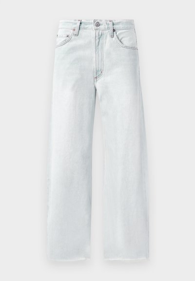 Jean large bleu clair en denim. Doté d'une taille à bouton, de cinq poches et d'un ourlet effiloché. Couture ton sur ton subtile.
