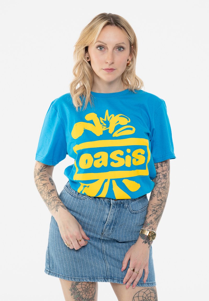 Blue cotton t-shirt with yellow "Oasis" graphic. Short sleeves, relaxed fit. Paired with a light blue denim skirt with vertical stripes.