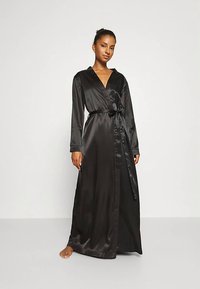 Svart sidenkappa med långa ärmar, omlottmodell och ett skärp i samma tyg, med en mjuk struktur och golvlång siluett.