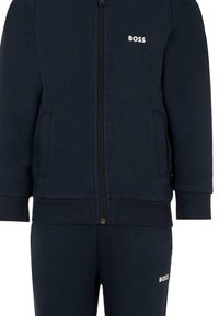 Felpa zip-up blu navy e pantaloni coordinati con tasche laterali, entrambi con il logo "BOSS" in testo bianco.