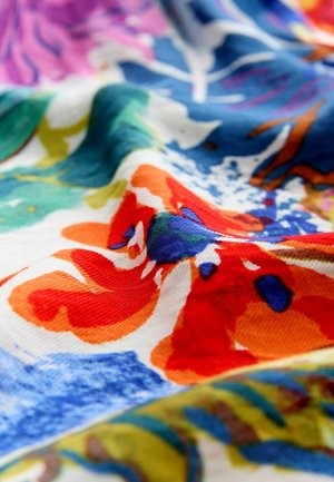 Material textil colorat cu un model floral în nuanțe vibrante de portocaliu, albastru și verde. Textura este moale, cu un ușor luciu.