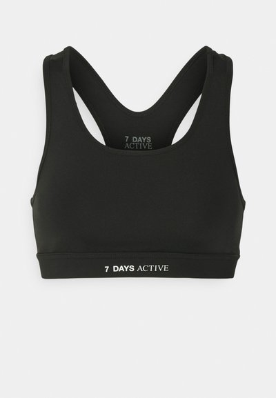 Melnā sporta krūšturis, izgatavots no elastīga auduma, ar sacensību aizmuguri un balto logo, kas uz joslas rakstīts "7 DAYS ACTIVE".