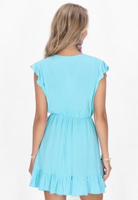 Rochie bleu deschis, cu mânecă scurtă, cu talie ajustată și tiv evazat cu volane, realizată dintr-un țesătură netedă, cu detalii minime.