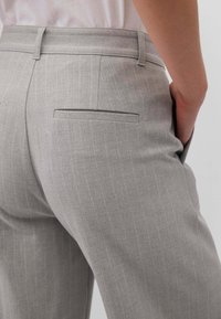 Pantaloni grigi a righe sottili con taglio dritto, tasca posteriore e texture liscia, progettati con una vita su misura e dettagli delle cuciture.