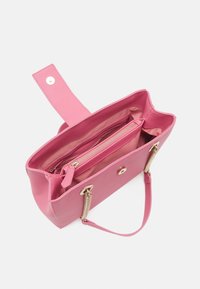 Rosa handväska gjord av syntetiskt material med en slät yta. Har en dragkedjeficka, gyllene detaljer och ett avtagbart band.