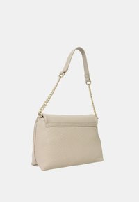 Sac à main en cuir beige avec une surface texturée, de forme rectangulaire et une chaîne amovible. Dispose d'une fermeture à rabat lisse.