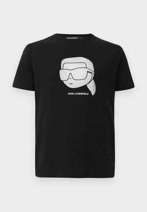 Camiseta de algodón negra con un gráfico blanco de un personaje estilizado que lleva gafas de sol grandes, con el texto "KARL LAGERFELD" debajo de la imagen.