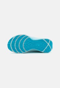Athletic shoe sole in light blue with a textured pattern, featuring grooves and vents for traction and breathability.