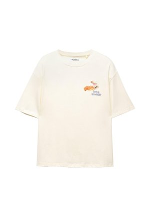 Crème-kleurige katoenen t-shirt met korte mouwen, voorzien van een grafisch ontwerp van een kopje en croissant, en de tekst "Lekker & Onweerstaanbaar."