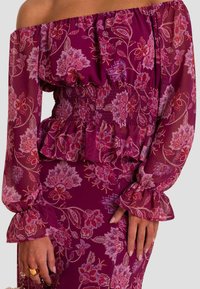 Paarse bloemen off-shoulder jurk van doorschijnende stof, met een smock taille, ruches mouwen en ingewikkelde roze bloemmotieven overal.