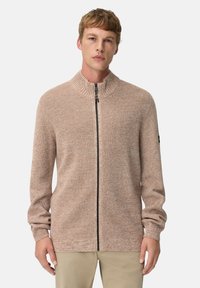 Beige gestrickter Reißverschluss-Pullover mit hohem Kragen und strukturiertem Stoff; verfügt über lange Ärmel und einen Frontreißverschluss mit schwarzen Hardware-Akzenten.