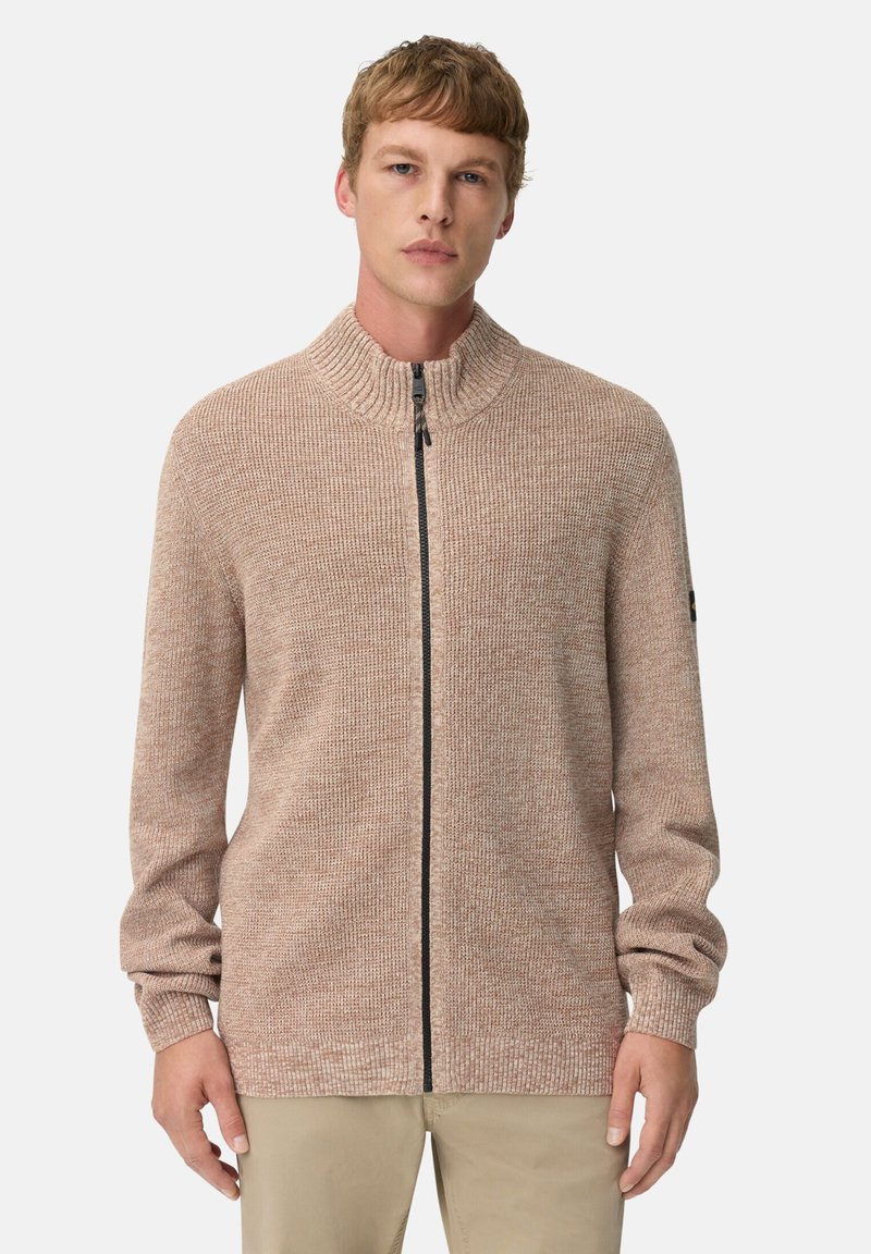 Beige gestrickter Reißverschluss-Pullover mit hohem Kragen und strukturiertem Stoff; verfügt über lange Ärmel und einen Frontreißverschluss mit schwarzen Hardware-Akzenten.