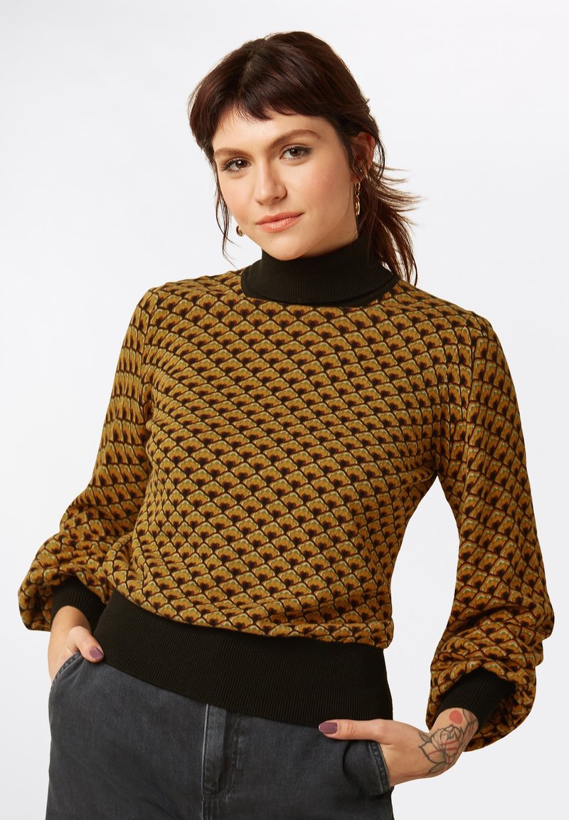 Neule turtleneck -pusero, jossa on geometrinen kuvio ruskean ja kullan sävyissä, mustat joustavat hihansuut ja helma. Pehmeä rakenne, istuva muotoilu.