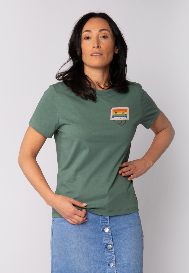 Grünes Baumwoll-T-Shirt mit einem Kassettendesign in Rot, Gelb und Blau auf der Brust, Rundhalsausschnitt und kurzen Ärmeln.