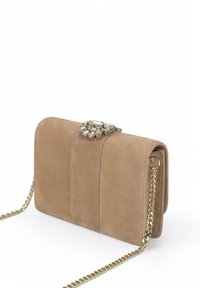 Bolso de mano de ante beige con una correa de cadena dorada. Presenta un cierre decorativo de strass y una textura a rayas en la parte frontal. Forma rectangular compacta.