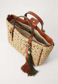 Geflochtene Strohtasche mit braunen Ledergriffen. Verfügt über einen bunten Quastenakzent, ein geräumiges Innenfach und goldene Beschläge.