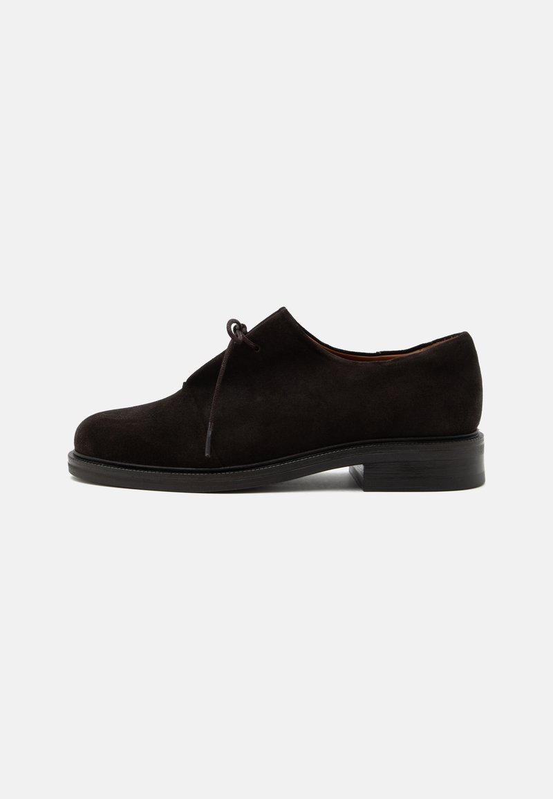Chaussure habillée en daim noir à talon bas, bout arrondi et lacet unique noué à l'avant, vue de profil sur fond uni.