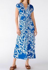 Robe maxi à motif floral bleu et blanc avec un décolleté en V profond, des manches courtes et un détail de taille nouée. Tissu lisse ; design longueur cheville.