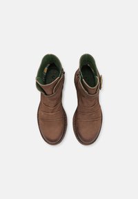 Botas de tornozelo em couro castanho com acabamento texturizado, apresentando um forro interior verde, fechos de zíper e um detalhe decorativo em botão.