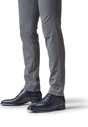 Dunkelblaue Lederschuhe mit glattem Finish, spitzer Zehe und Schnürsenkeln. Kombiniert mit maßgeschneiderten grauen Hosen mit sauberer, eleganter Passform.