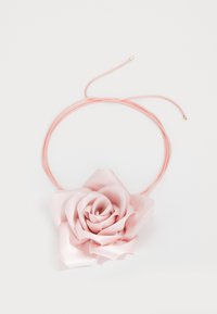 Vaaleanpunaisesta satiinista valmistettu ruusuketju ohuehkolle vaaleanpunaiselle narulle, jonka päässä on kultaiset päät. Kukassa on kerroksellisia terälehtiä, joissa on sileä pinta ja hienovarainen kiilto.