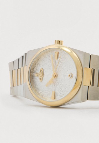 Relógio de pulso em prata e ouro com mostrador branco texturizado, marcadores de horas dourados e detalhes dourados numa bracelete metálica.