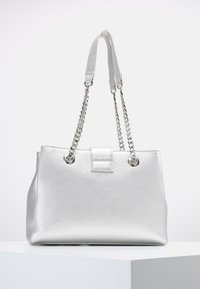 Silverfärgad handväska med textur, dubbel kedja och remmar, rektangulär form, en framficka med detaljer och metalliska accentdetaljer.